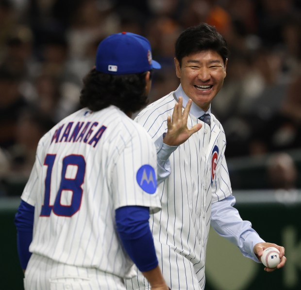 Former Japanese professional player and Cubs pitcher Hisanori Takahashi waves...