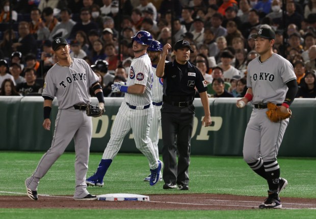Chicago Cubs outfielder Kyle Tucker, center, is called out for...