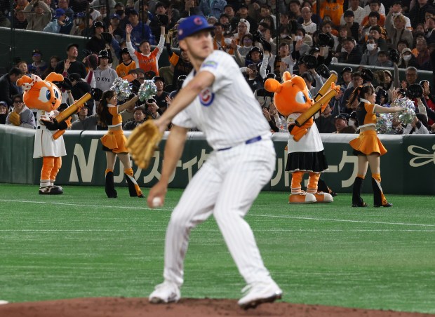 Chicago Cubs pitcher Jameson Taillon warms up to pitch the...