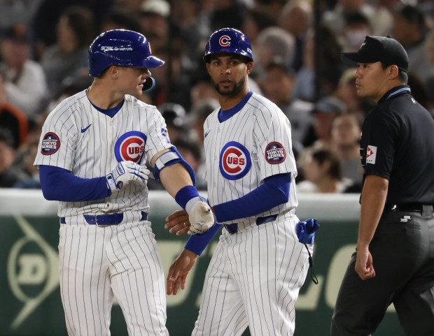 Cubs third baseman Matt Shaw, left, takes off his batting...