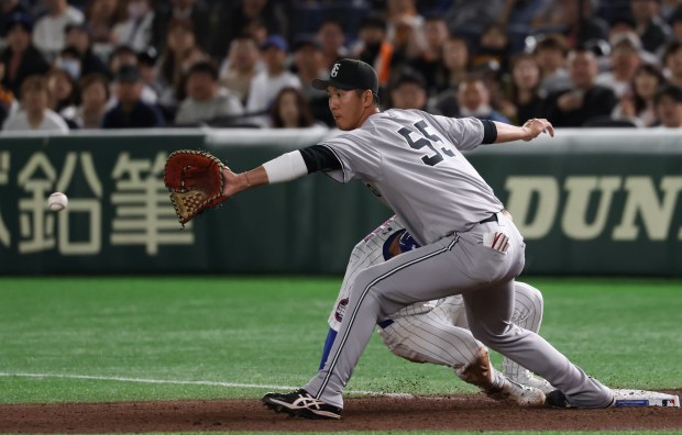 Yomiuri Giants first baseman Yuto Akihiro (55) reaches for the...