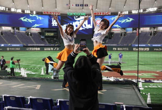 Cheerleaders wearing Dodgers jerseys pose for pictures before a two-game...