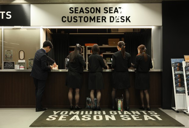 Stadium workers in suits prepare before the gates open a...