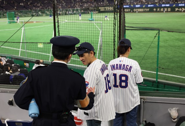Jinsuke and Ikue Go are instructed by a security worker...