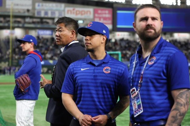 Former Cubs player Kosuke Fukudome, center left, watches batting practice...