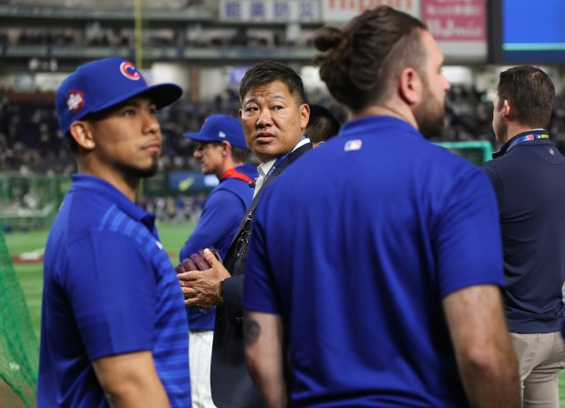 Former Cubs player Kosuke Fukudome, center, watches batting practice for...