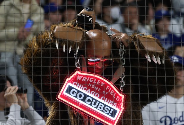 A Cubs fan adjusts his costume before the opening day...