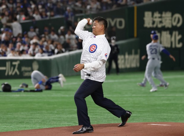 Former Cubs player Kosuke Fukudome throws the ceremonial first pitch...