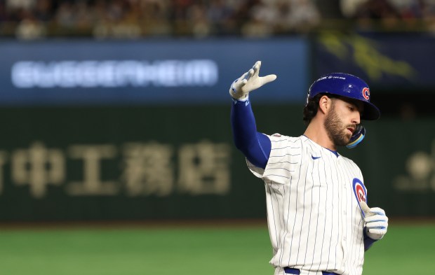 Cubs shortstop Dansby Swanson gestures after hitting a single against...