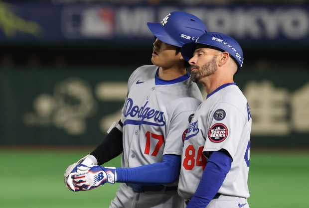 Dodgers designated hitter Shohei Ohtani (17) knocks helmets with first...