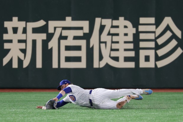 Cubs left fielder Ian Happ dives for an RBI single...