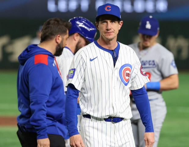Cubs manager Craig Counsell heads to the dugout after checking...