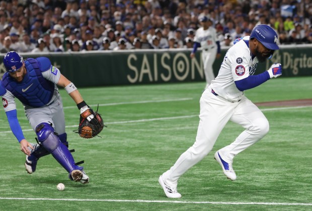 Cubs catcher Carson Kelly (15) reaches down for the ball...