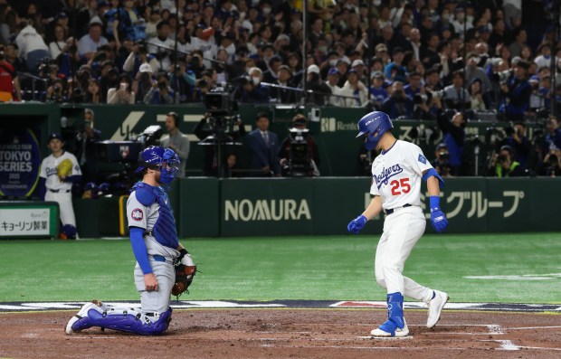 Cubs catcher Carson Kelly, left, waits for Dodgers second baseman...