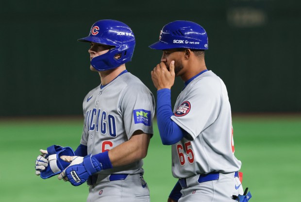 Cubs first baseman coach Jose Javier (65) talks to third...