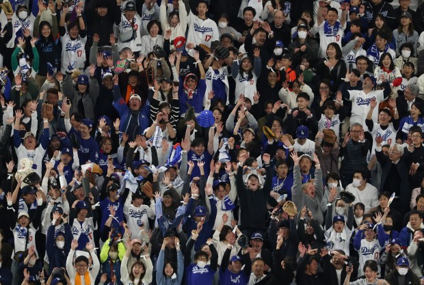Fans perform "the wave" in the eighth inning between the...