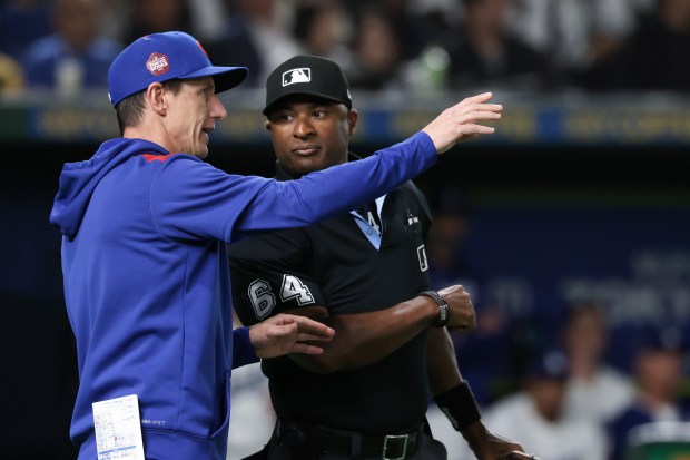 Cubs manager Craig Counsell talks with the home plate umpire...
