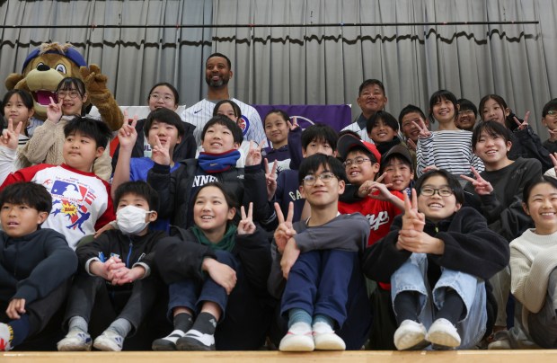 Former Cubs players Derrek Lee, top center left, and Kosuke...