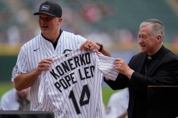 Cardinal Blase Cupich presents former White Sox player Paul Konerko with a jersey signed by Pope Leo XIV during a ceremony honoring the 2005 World Series champions July 12, 2025, at Rate Field. (AP Photo/Erin Hooley)