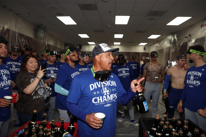 Dave Roberts of the Los Angeles Dodgers addresses the team in the locker room after defeating the Arizona Diamondbacks 8-0 to clinch the National League West title at Chase Field on September 25, 2025 in Phoenix, Arizona.
