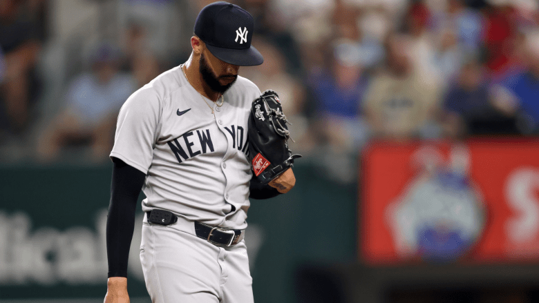 Yankees pitcher Devin Williams reacts after blowing a save against the Rangers as manager Aaron Boone looks on during a rough August 2025 series.