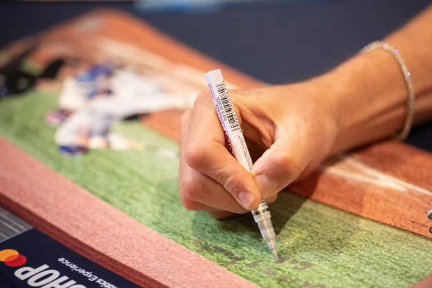 The Los Angeles Dodgers’ Miguel Rojas signs a photograph of...