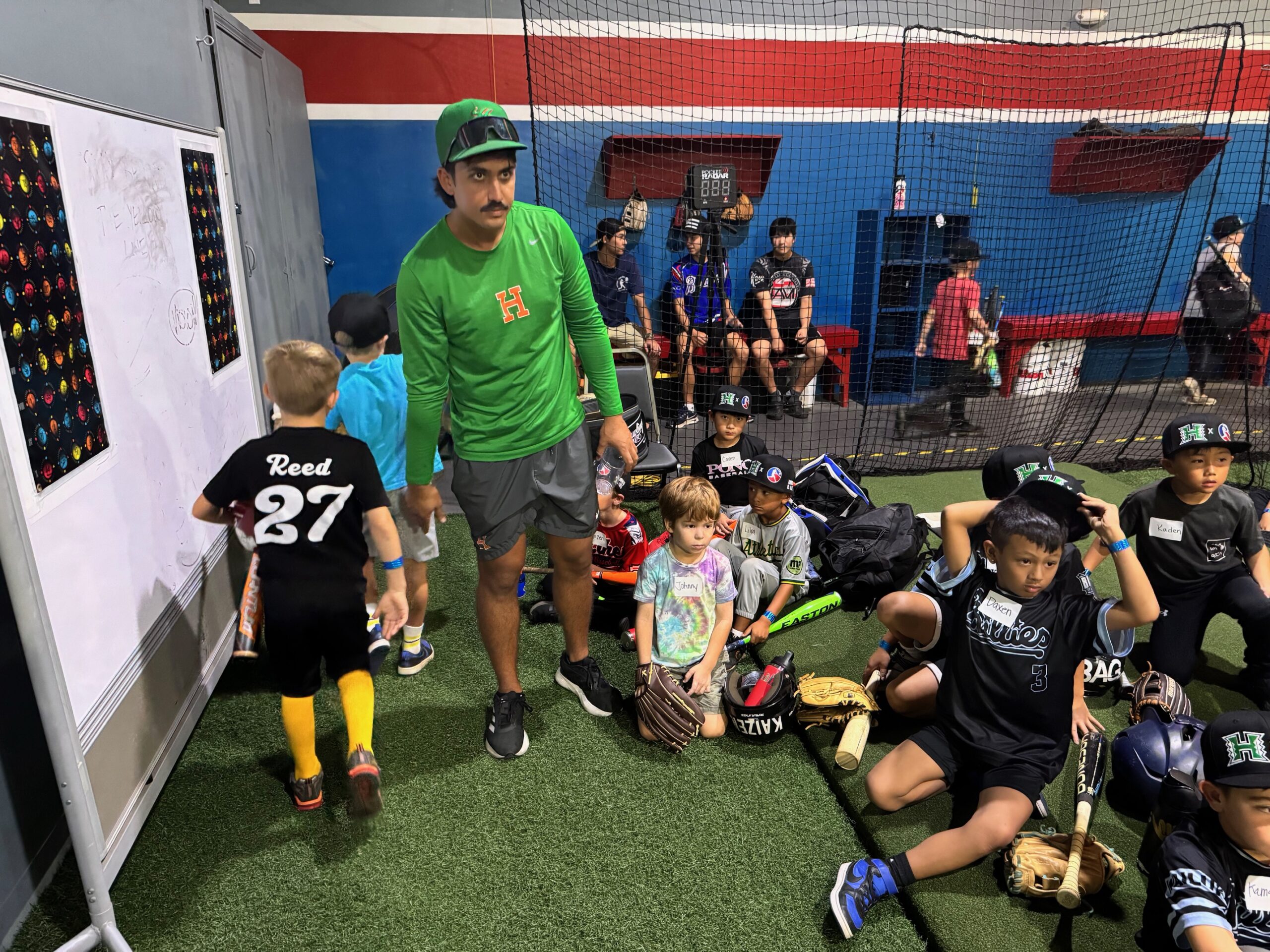University of Hawaii baseball player Ben Zeigler-Namoa works with young players on Saturday at a baseball clinic at Hitter's Paradise. HJI / ROB COLLIAS photo