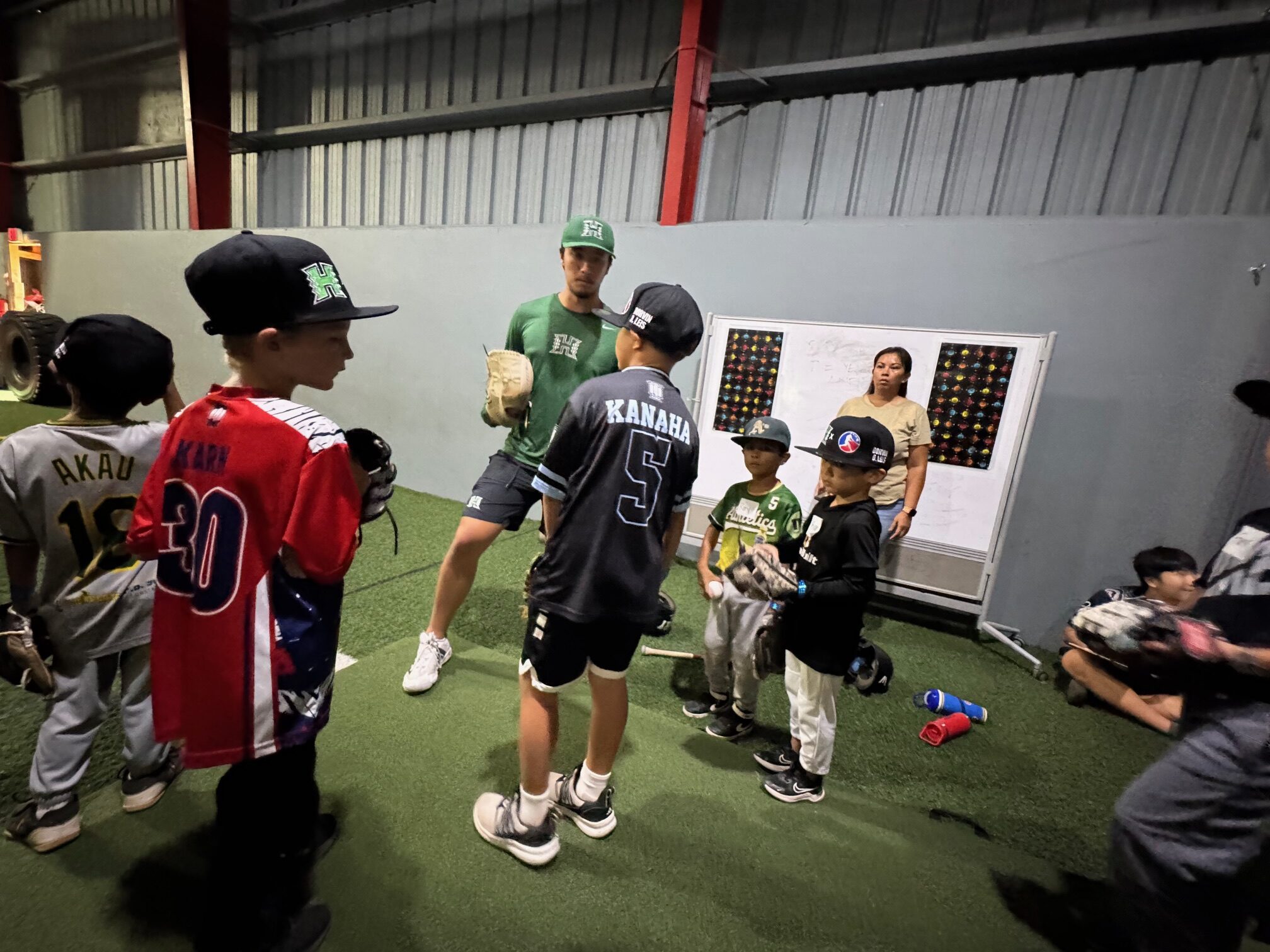 University of Hawai'i baseball player Dylan Waite (middle) works with young players on Saturday at a baseball clinic at Hitter's Paradise. HJI / ROB COLLIAS photo