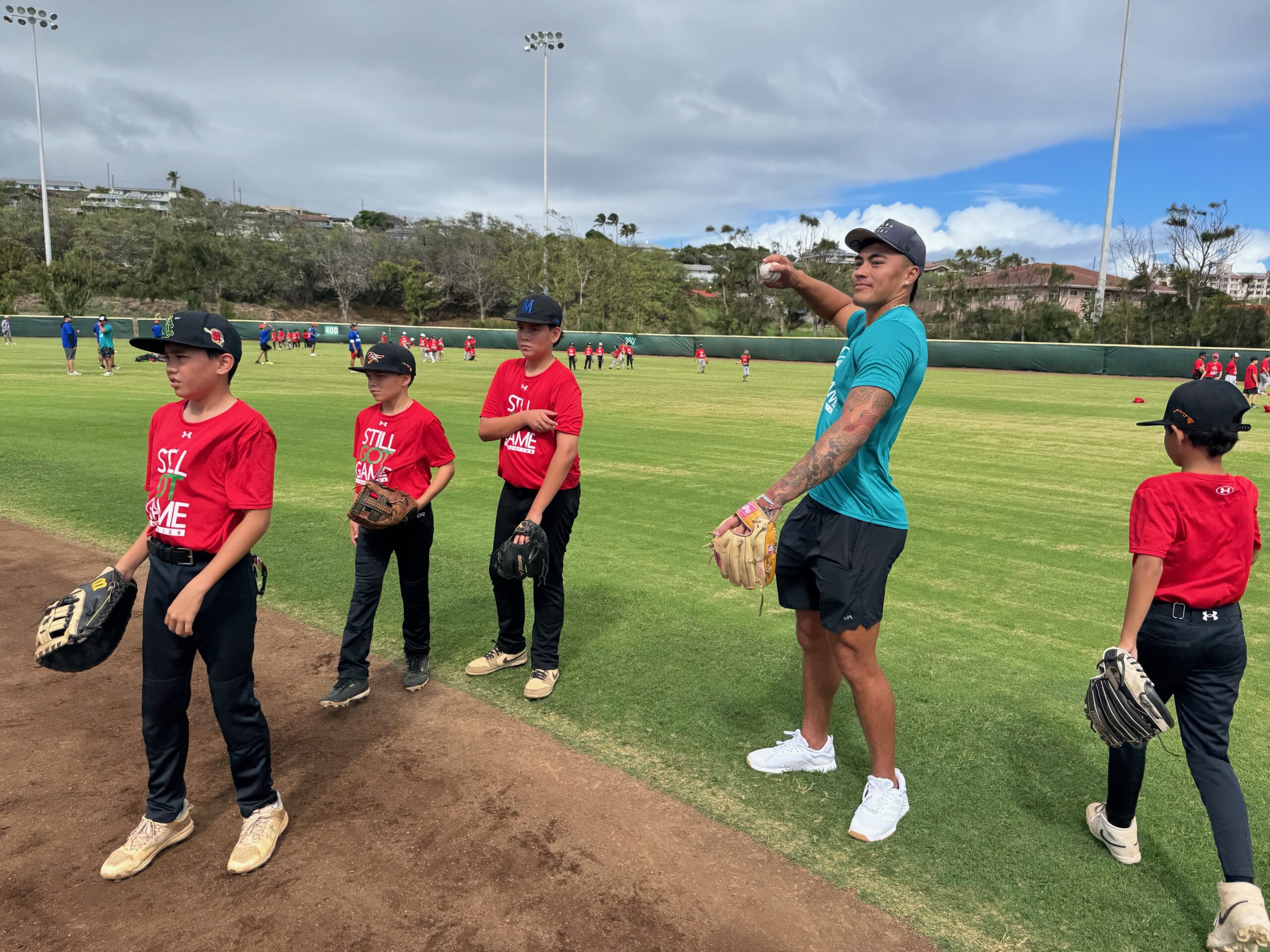 Wehiwa Aloy, a Baldwin High School graduate, Golden Spikes winner at the University of Arkansas and first-round draft choice of the Baltimore Orioles, works with youth baseball players at Maehara Stadium on Sunday. HJI / ROB COLLIAS photo