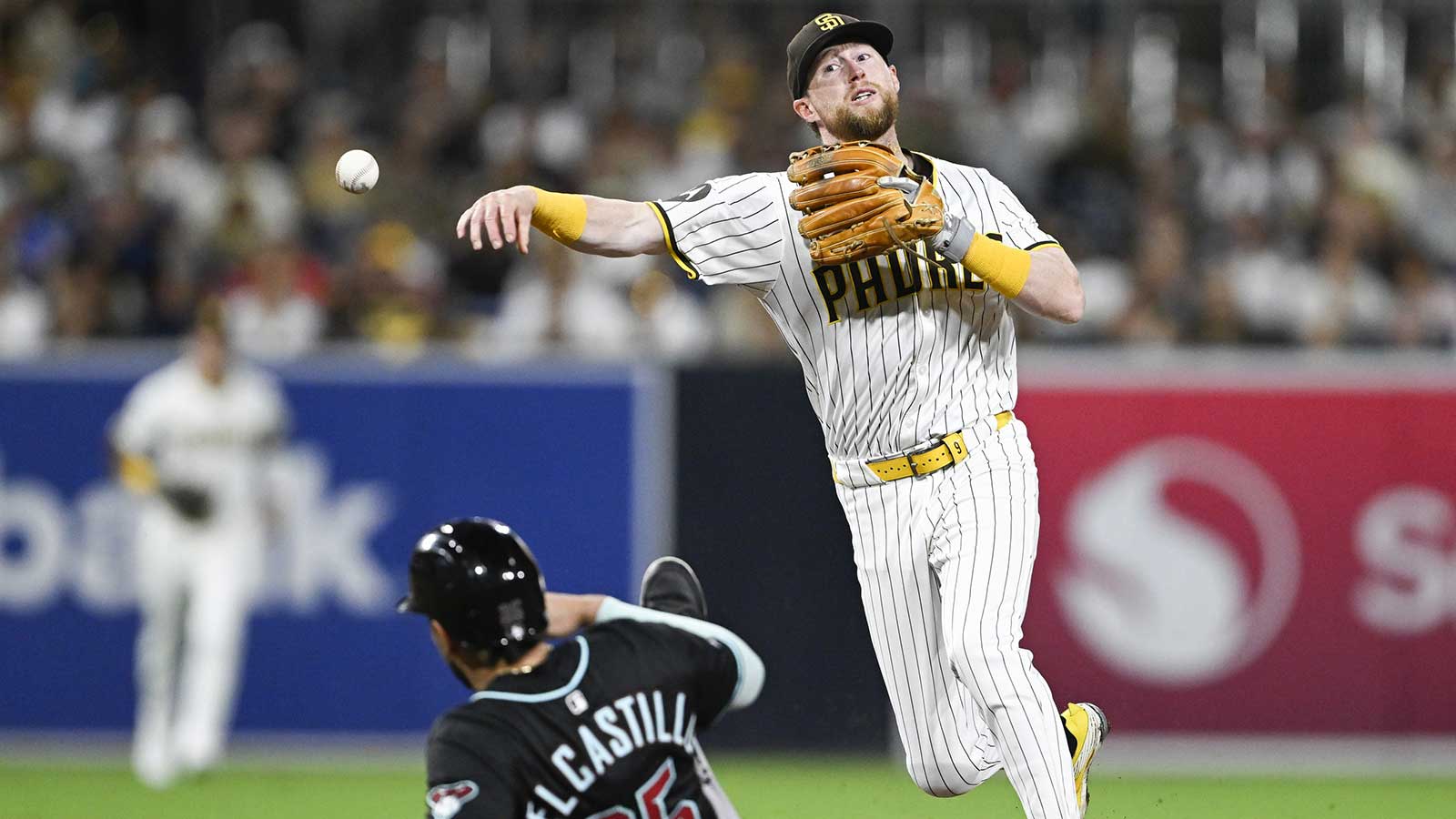  San Diego Padres second baseman Jake Cronenworth (9) throws over Arizona Diamondbacks catcher Adrian Del Castillo (25) as he turns a double play during the fifth inning at Petco Park. 