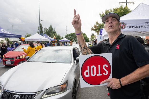 Erik Hatchett of the AIDS Healthcare Foundation helps direct traffic...