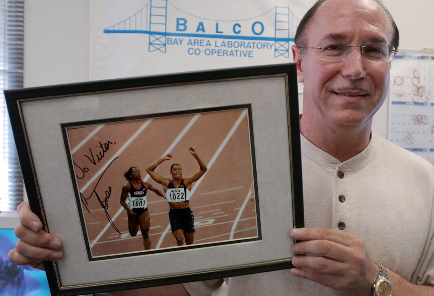 FILE - BALCO founder Victor Conte holds up an autographed photo addressed to Conte of track star Ma...