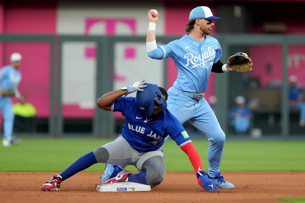 Kansas City Royals shortstop Bobby Witt Jr., top, throws to first base past Toronto Blue Jays'...