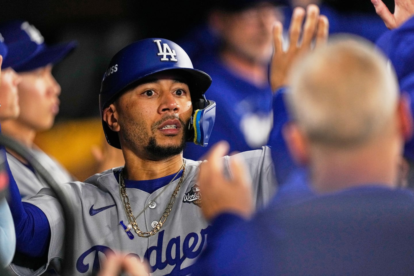 Los Angeles Dodgers' Mookie Betts celebrates in the dugout after scoring on a sacrifice fly against the Toronto Blue Jays during the sixth inning in Game 7.