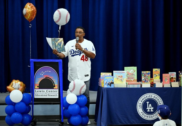 Former Los Angeles Dodgers player Dennis Powell reads “Abuela” on...