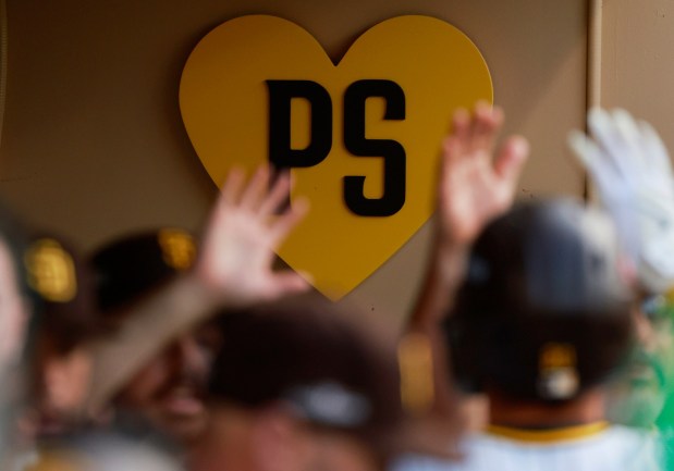 A heart with the letters PS for the late San Diego Padres owner Peter Seidler hangs in the dugout during a wild card playoff game against the Atlanta Braves at Petco Park on Tuesday, Oct., 2024. (K.C. Alfred / The San Diego Union-Tribune)