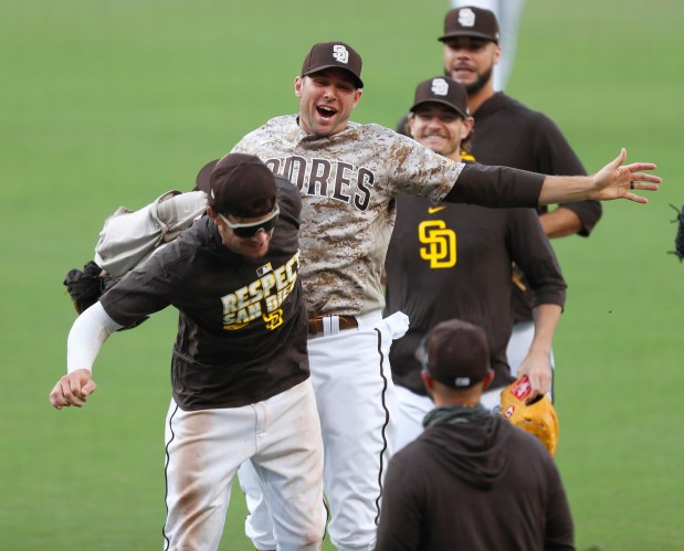 Will Myers, left, and pitcher Craig Stammen of the San Diego Padres celebrate after beating the Seattle Mariners and clinching a playoff spot at Petco Park on Sunday, Sept.20, 2020 in San Diego, CA. (K.C. Alfred / The San Diego Union-Tribune)