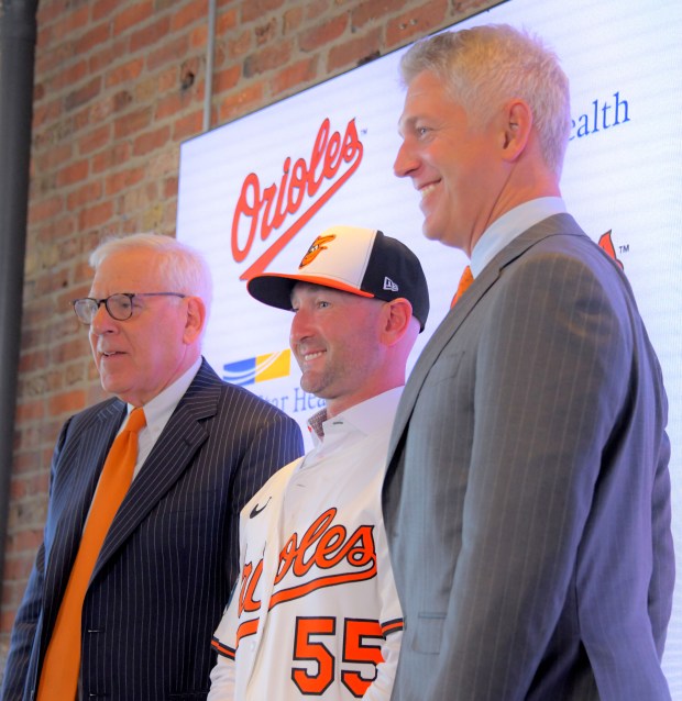 Craig Albernaz, newly hired as manager of the Baltimore Orioles, center is flanked by David Rubenstein, control owner while Mike Elias, team president of baseball operations and general manager during a press conference at Oriole Park at Camden Yards. (Karl Merton Ferron/Staff)