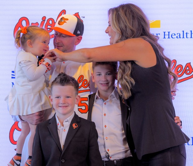 Craig Albernaz, newly hired as manager of the Baltimore Orioles holds Genevieve Elizabeth Albernaz, who looks at mother Genevieve Albernaz while sons Norman Albernaz and C.J. Albernaz stand between their parents during a press conference at Oriole Park at Camden Yards. (Karl Merton Ferron/Staff)