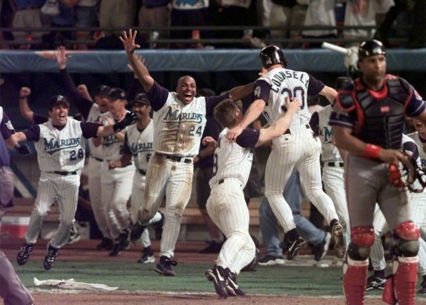 The Marlins' Craig Counsell is greeted by teammates, including Bobby Bonilla (24) and John Cangelosi (28), after he scored the winning run on Edgar Renteria's hit in Game 7 of the 1997 World Series against the Indians. Florida won, 3-2, in 11 innings. (Eric Draper - The Associated Press)