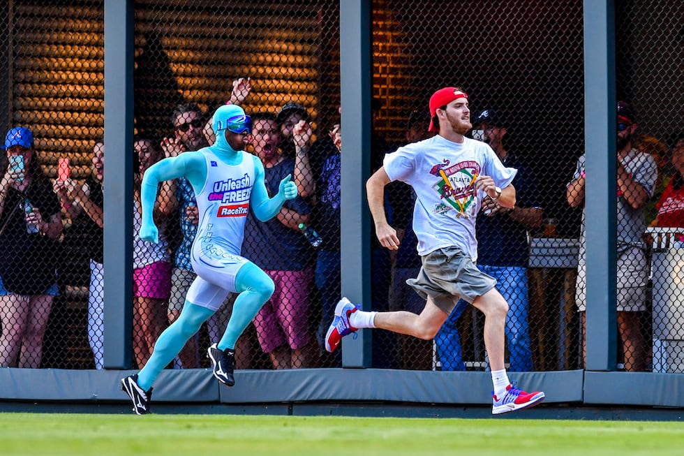 An Atlanta Braves fan beats The Freeze in a race during a baseball game against the Milwaukee...
