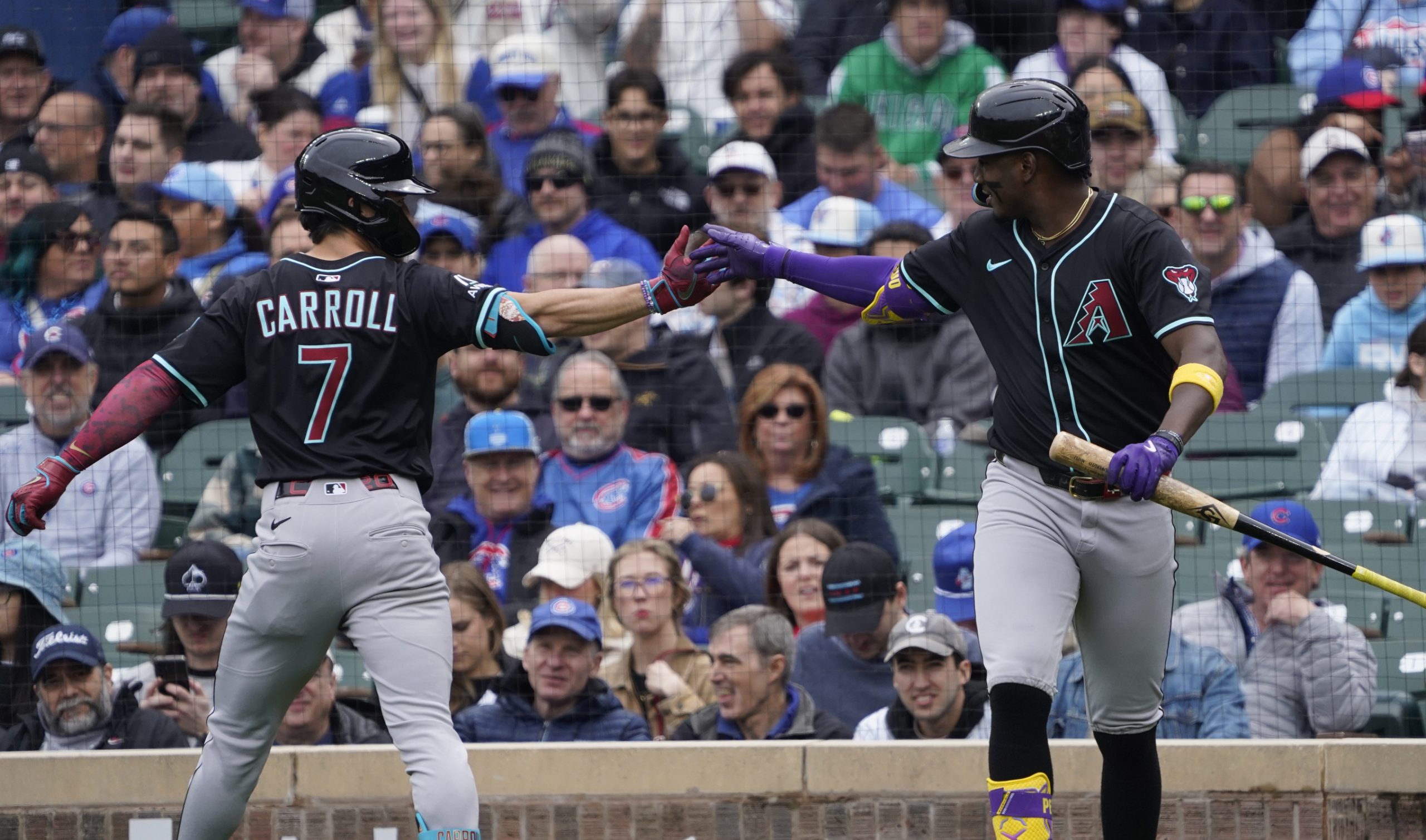 Apr 19, 2025; Chicago, Illinois, USA; Arizona Diamondbacks outfielder Corbin Carroll (7) is greeted by shortstop Geraldo Perdomo (2) after hitting a home run against the Chicago Cubs during the first inning at Wrigley Field. Mandatory Credit: David Banks-Imagn Images
