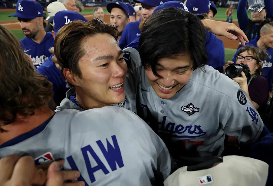 Dodgers pitcher Yoshinobu Yamamoto, left, celebrates with Shohei Ohtani and teammates.