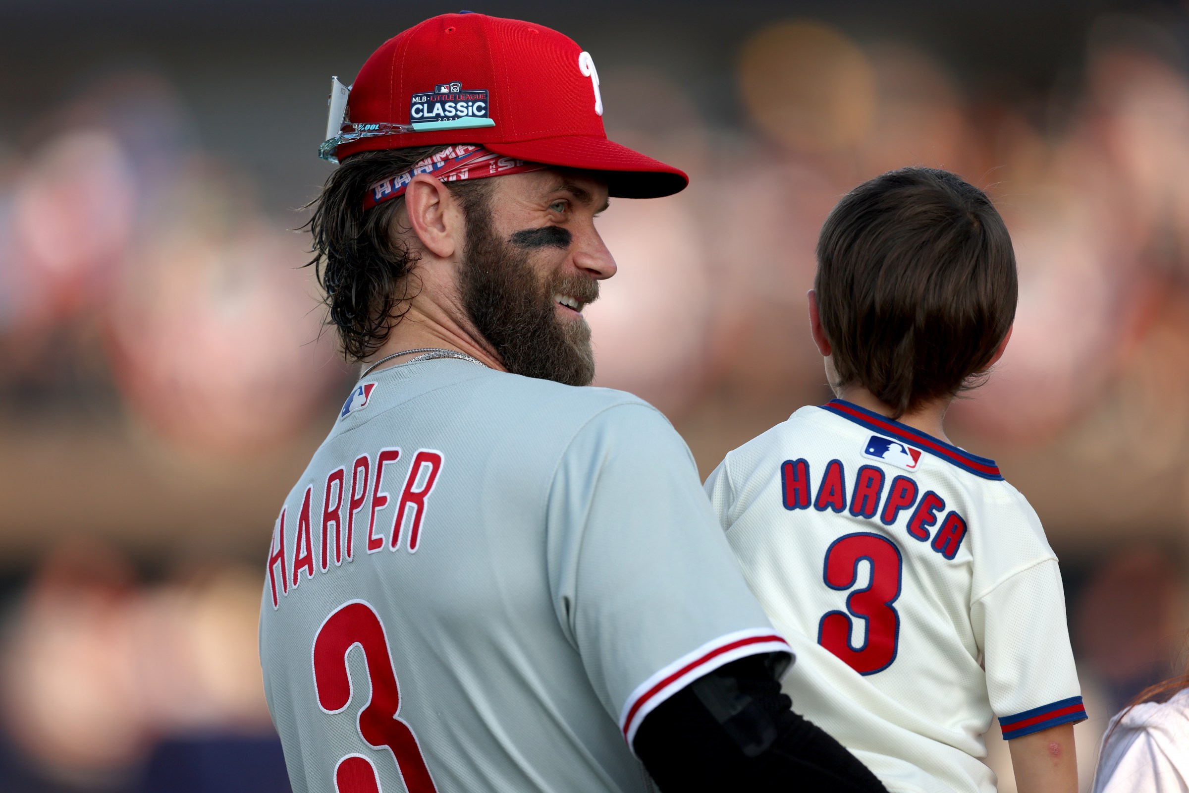 SOUTH WILLIAMSPORT, PENNSYLVANIA - AUGUST 20: Bryce Harper #3 of the Philadelphia Phillies talks with his son Krew before the start of the 2023 Little League Classic against the Washington Nationals at Bowman Field on August 20, 2023 in South Williamsport, Pennsylvania. (Photo by Rob Carr/Getty Images)