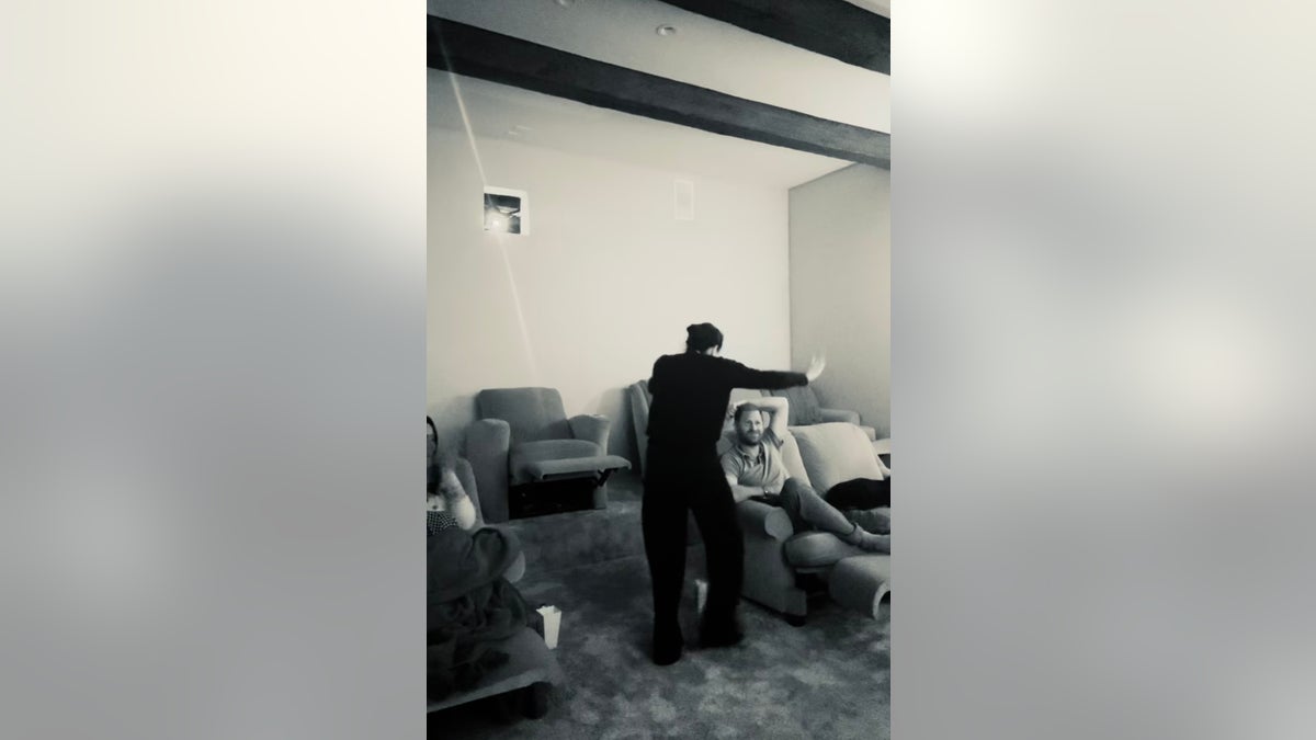 Meghan Marlle walks over to a seated Prince Harry. 