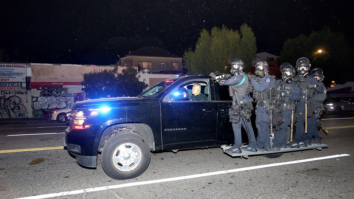 Police officers wearing helmets monitoring streets