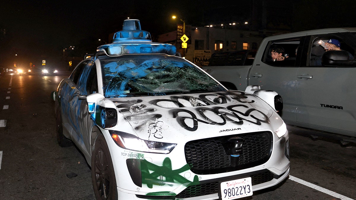 Waymo vehicle with broken windows and graffiti