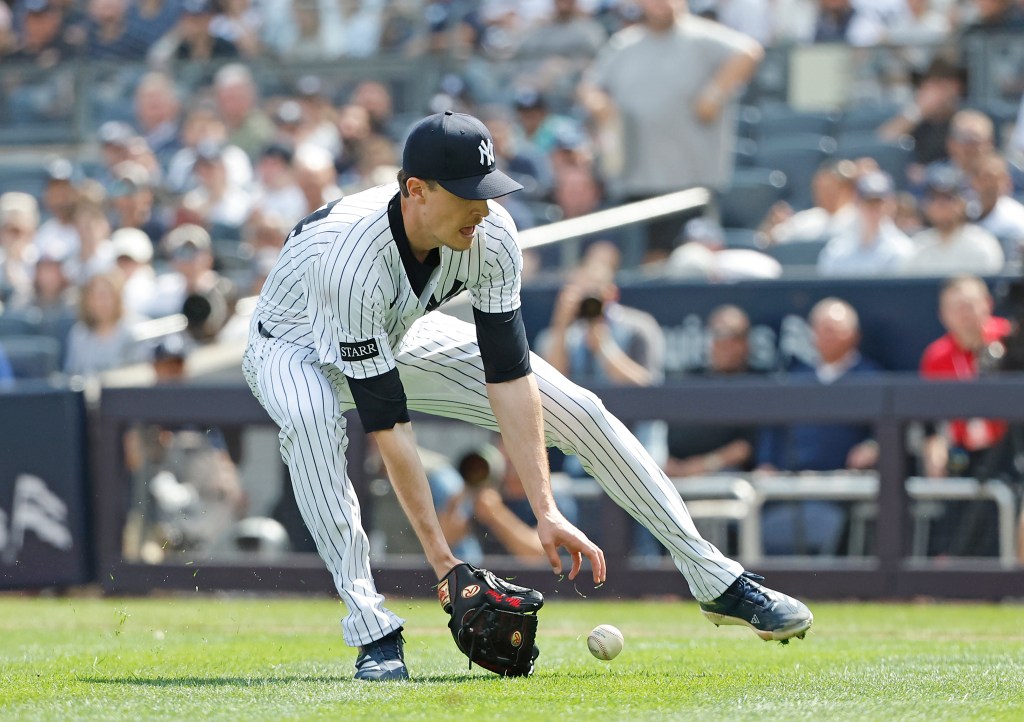 New York Yankees pitcher Max Fried makes a throwing error on a ball hit by Milwaukee Brewers outfielder Christian Yelich allowing Yelich to safely reach first and a run scored during the second inning at Yankee Stadium in the Bronx, New York, USA, Saturday, March 29, 2025.