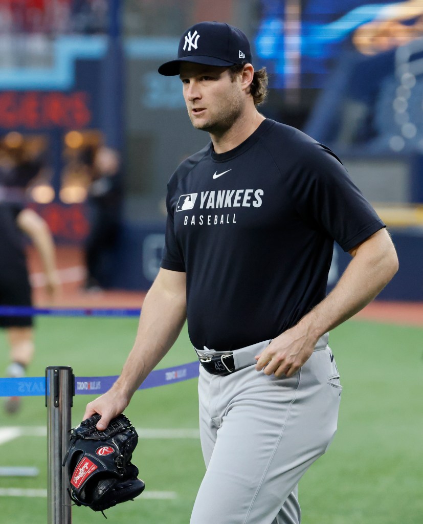 New York Yankees pitcher Gerrit Cole in a black Yankees t-shirt and hat, holding a black glove.