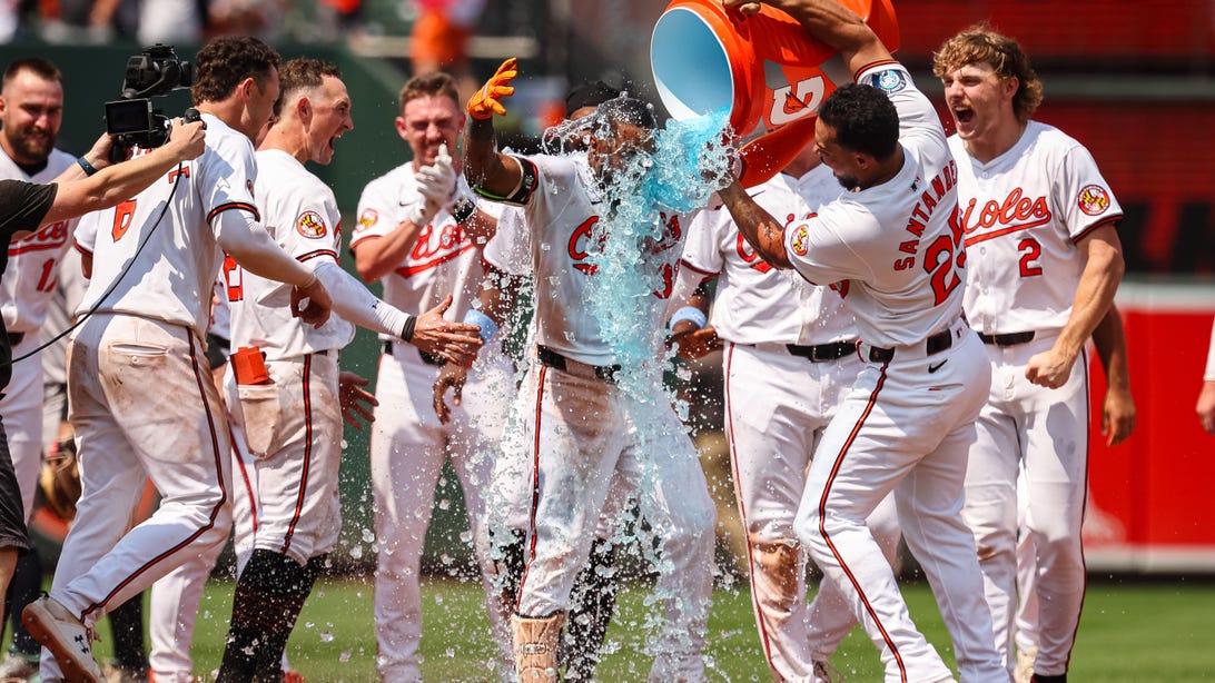 BALTIMORE, MD - JULY 14: Anthony Santander #25 of the Baltimore Orioles dumps Gatorade on Cedric Mullins #31 after Mullins hits a two RBI double against Clay Holmes #35 of the New York Yankees during the ninth inning to win the game at Oriole Park at Camden Yards on July 14, 2024 in Baltimore, Maryland.